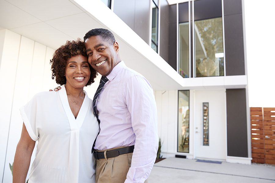 Personal Insurance - Couple Standing Outside and Admiring Their New Modern Home