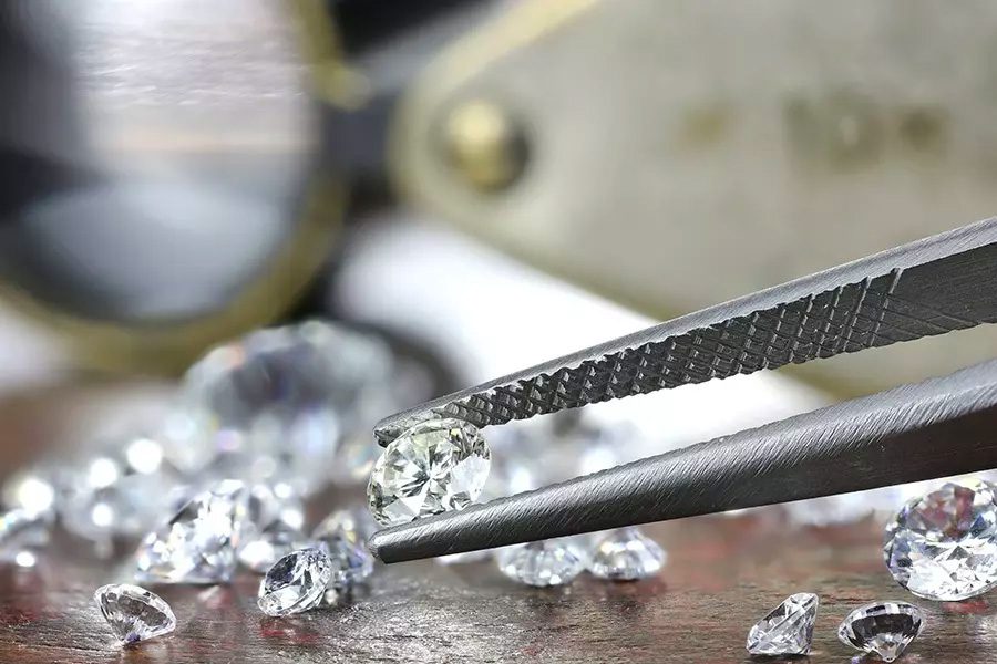Jewelers-Insurance-Closeup-View-of-Brilliant-Cut-Diamond-Held-by-Jeweler-Using-Tweezers